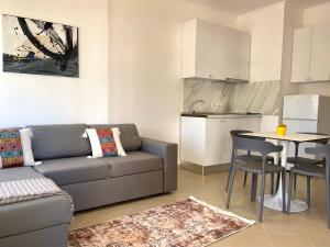 Il comprend un salon avec un canapé et une table. dans l'établissement Sunrise Golem Summer Apartment, à Durrës