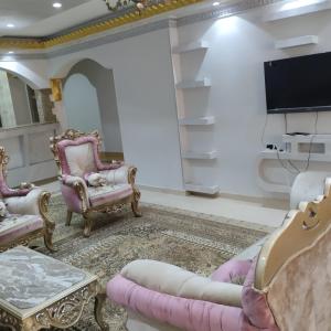 a living room with two chairs and a flat screen tv at شقة مفروشة سوبر لوكس للايجار in Cairo