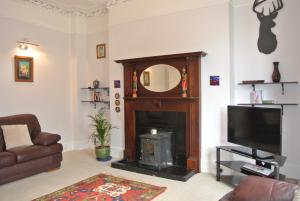 a living room with a fireplace and a tv at 26 Belvidere Crescent Apartment in Aberdeen