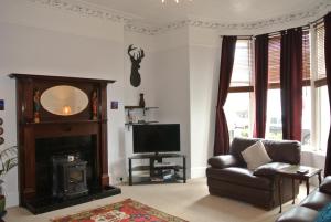 a living room with a couch and a television at 26 Belvidere Crescent Apartment in Aberdeen