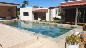 a swimming pool in front of a house at Mangues Oasis in Rodrigues Island