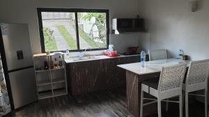 cocina con fregadero, mesa y ventana en Mangues Oasis, en Rodrigues Island