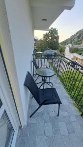 a balcony with a table and a chair on a patio at Spasic Apartments Sutomore in Sutomore