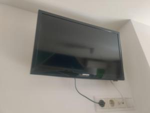 TV de pantalla plana colgada en la pared en Apartamento Turistico Dct. Creus, en Guadalajara