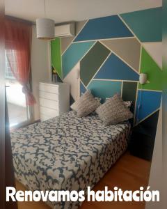 1 dormitorio con 1 cama con pared geométrica en Apartamento Turistico Dct. Creus, en Guadalajara