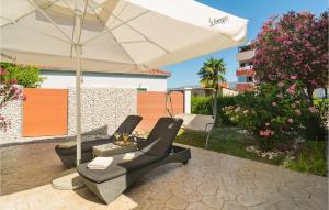 a patio with two chairs and an umbrella at Amazing Home In Split With Wifi in Split