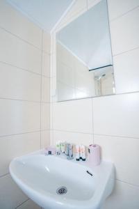y baño con lavabo blanco y espejo. en VILA PUPA, Elešec 2 en Ohrid