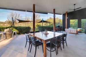 a dining room with a wooden table and chairs at The Sticks in Goughs Bay