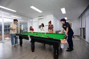 a group of people standing around a pool table at MekongView 3 CondoTel in Phnom Penh