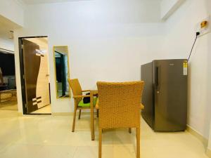 a room with a table and chairs and a refrigerator at Saba 502, Subko Coffee, Chapel Road, Bandra West by Connekt Homes in Mumbai