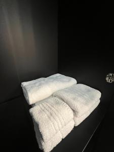 tre asciugamani bianchi seduti su un bancone in una stanza di Holiday time a Castellammare di Stabia