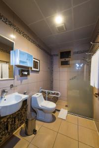 a bathroom with a toilet and a sink and a shower at Boudl Al Fakhria in Unayzah