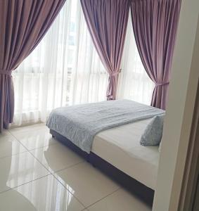 a bedroom with a bed with purple curtains and windows at BS City Homestay2 - Miri Times Square in Miri