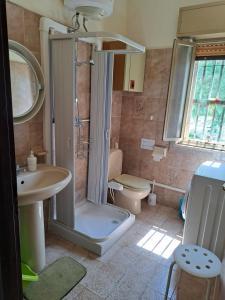 a bathroom with a shower and a toilet and a sink at Villino Relax in Portopalo