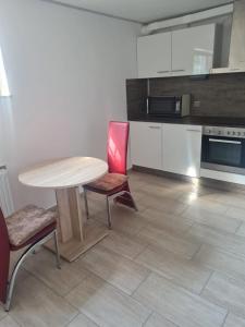 a kitchen with a wooden table and two chairs at Appartement Willmeroth in Königswinter +5 photos