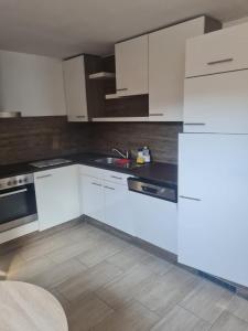 una cucina con armadi bianchi e lavandino di Appartement Willmeroth a Königswinter