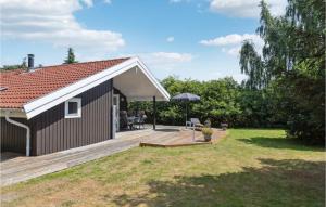 een klein huis met een houten terras in een tuin bij Beautiful Home In Vggerlse With Kitchen in Bøtø By