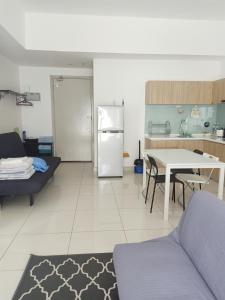 a kitchen and living room with a refrigerator and a table at BS City Homestay2 - Miri Times Square in Miri