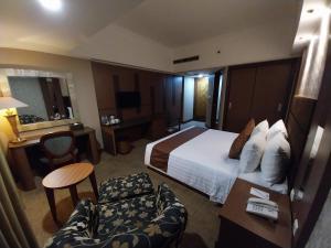 ein Hotelzimmer mit einem Bett, einem Schreibtisch und einem Stuhl in der Unterkunft Horison Ultima Menteng Jakarta in Jakarta