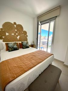 una camera da letto con un grande letto con una grande finestra di MyChoice Frida by Bossh! Apartments a Rota