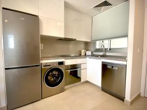 una cucina con lavatrice e lavastoviglie di MyChoice Frida by Bossh! Apartments a Rota