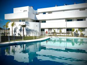 una piscina di fronte a un edificio di MyChoice Frida by Bossh! Apartments a Rota