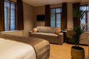 a living room with a bed and a couch at Hotel de Boskar Houthalen in Houthalen-Helchteren