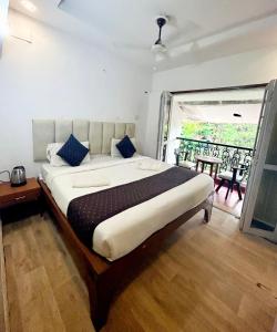 a bedroom with a large bed and a large window at Goa Divine Candolim in Calangute