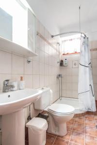 a white bathroom with a toilet and a sink at Theoni’s country house with garden and sea view in Alexandroupoli