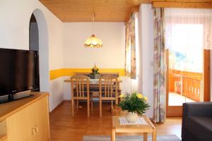 a living room with a table and a dining room at Haus Obere Allmein in Sankt Gallenkirch