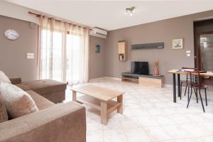 uma sala de estar com um sofá e uma mesa em Theoni’s country house with garden and sea view em Alexandroúpolis