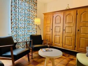 sala de estar con 2 sillas y mesa en Quiet holiday home in Valkenburg en Valkenburg