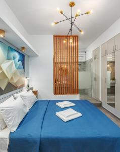 a bedroom with a blue bed with towels on it at Theo's Cozy Apartment near Athens airport in Spata