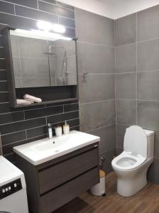 a bathroom with a sink and a toilet and a mirror at Oasis Apartments in Áyios Andréas