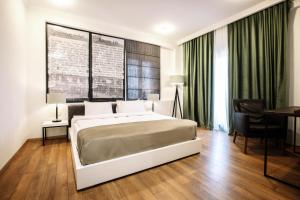 فندق سيتادِل ناريكالا في تبليسي: غرفة نوم بسرير وطاولة ومكتب