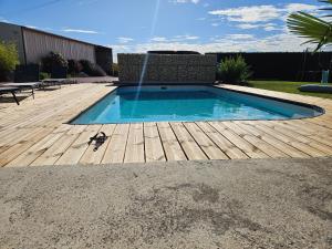 - une piscine sur une terrasse en bois avec une fontaine dans l'établissement Le Repaire de Bacchus, à Saint-Nicolas-de-Bourgueil