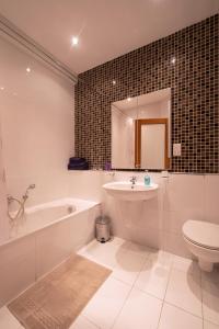 uma casa de banho com uma banheira, um lavatório e um WC. em Brand new listing located just off Sliema seafront em Sliema