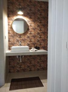 a bathroom with a sink and a mirror on a wall at Oasis Apartments in Áyios Andréas