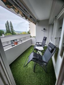 a balcony with two chairs and a table at Ferienwohnung Sakowski in Lörrach