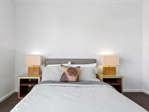 a white bed with two nightstands and two lamps at Sara by Ready Set Stay in Caroline Springs