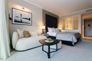 ein Hotelzimmer mit einem Bett und einem Sofa in der Unterkunft La Réserve Resort in Knokke-Heist