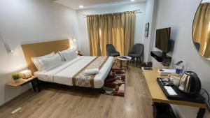 a hotel room with a bed and a desk at Saltstayz Sector 39 - Near Medanta Hospital in Gurgaon