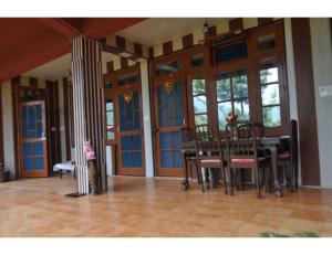 una sala da pranzo con tavolo, sedie e finestre di Safaya Paying Guest House and Home Stay, Patnitop a Patnitop