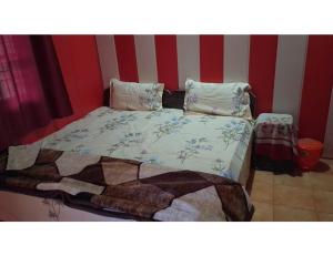 un letto in una stanza a strisce rosse e bianche di Safaya Paying Guest House and Home Stay, Patnitop a Patnitop