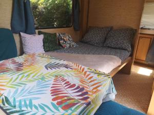 a bed and pillows in an rv at Caravane Vintage Esparadenn l'esprit d'antan in Guengat