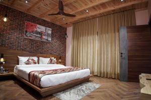 ein Schlafzimmer mit einem großen Bett und einer Ziegelwand in der Unterkunft Whispering Pines in Bhīm Tāl