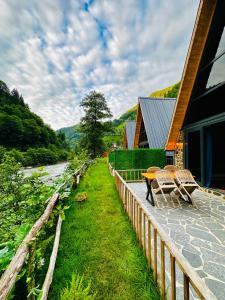 une terrasse avec une table et des chaises à côté d'une maison dans l'établissement Seyridere süit bungalov, à Çamlıhemşin