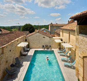 a person swimming in a swimming pool in a villa at hideauts hotels Le Chevalier bleu in Monpazier