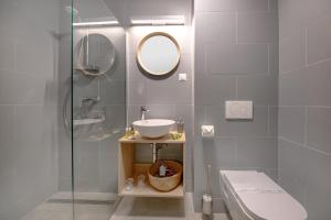 a bathroom with a sink and a toilet and a mirror at Tihany Yacht Club in Tihany