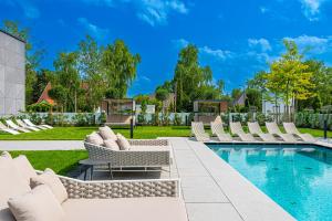 um pátio com espreguiçadeiras e uma piscina em REED Luxury Hotel by Balaton em Siófok